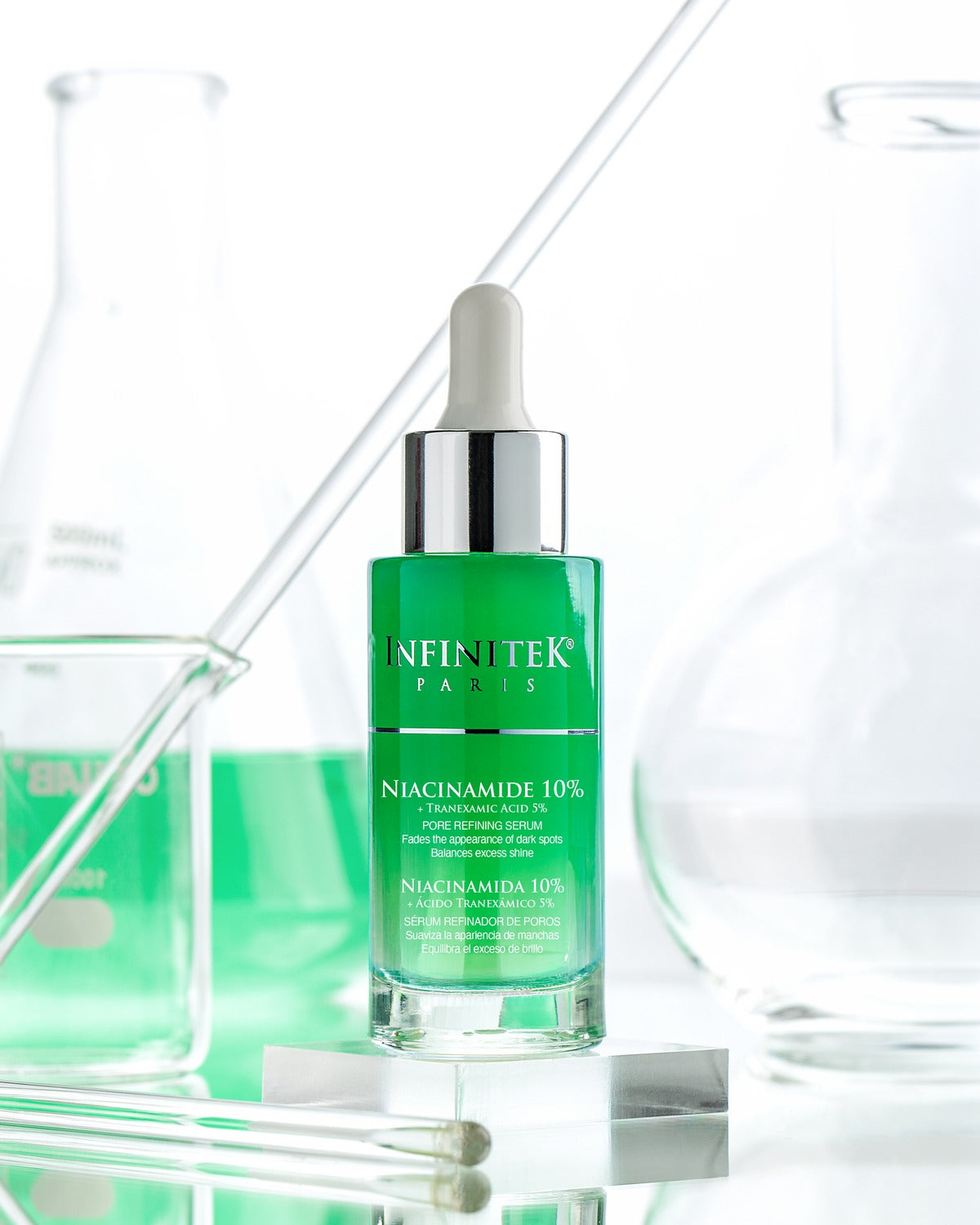 Sérum Niacinamida 10% + Ácido Tranexámico 5% de Infinitek Paris entre material de laboratorio