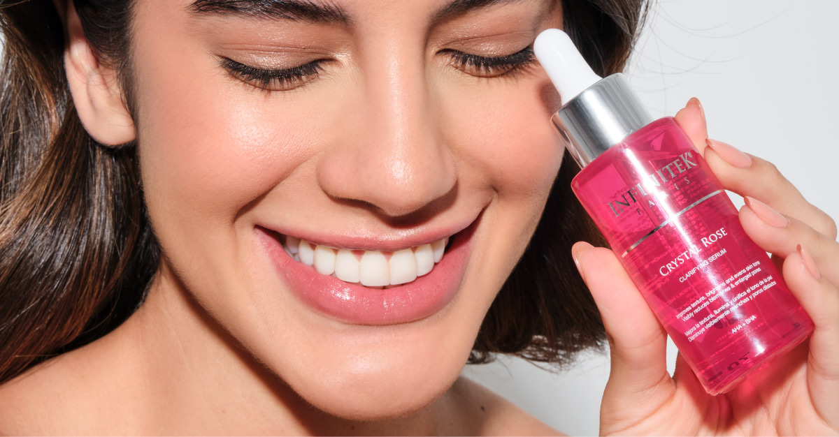 mujer latina sonriente con piel hermosa sosteniendo crystal rose serum de infinitek paris