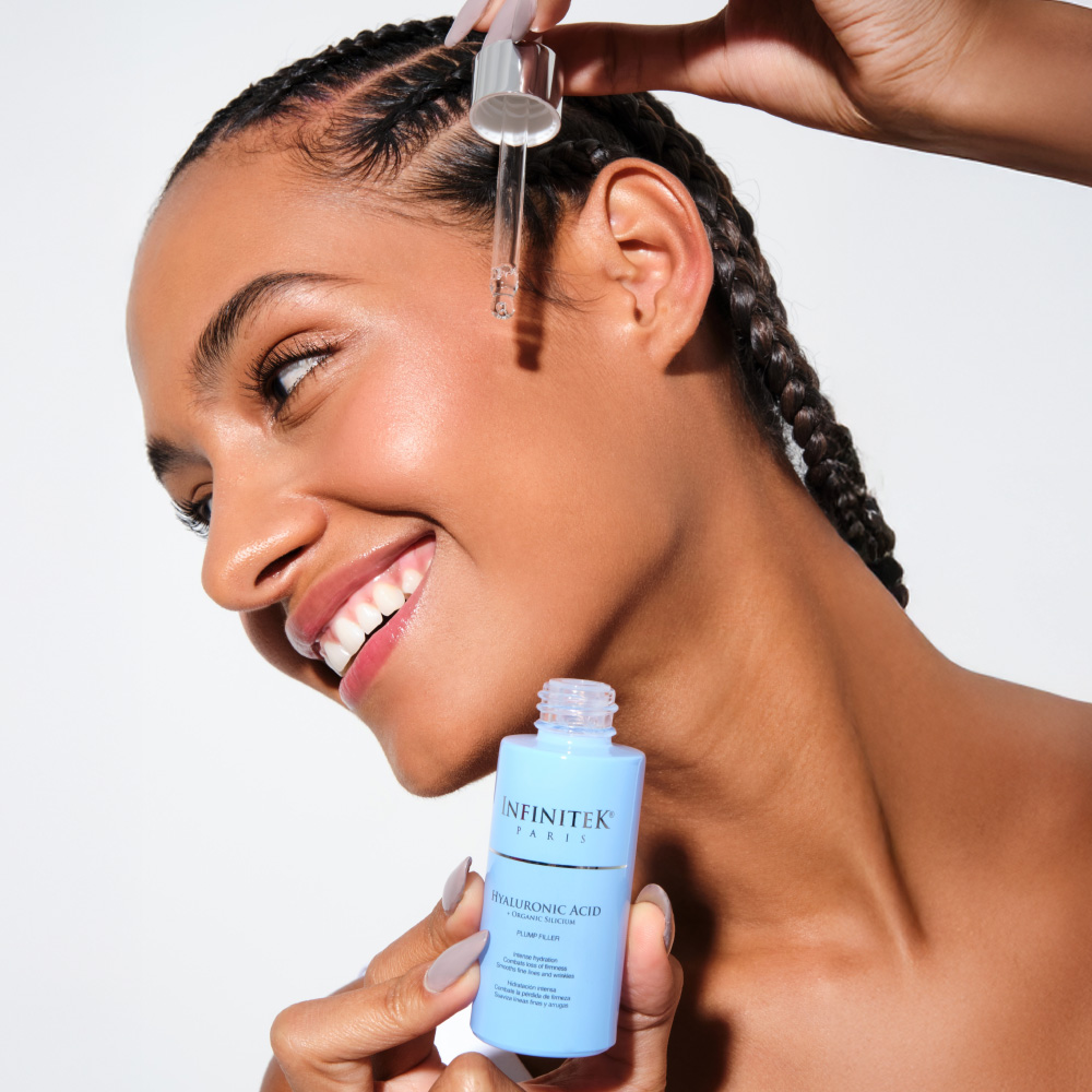 mujer modelo afro aplicandose en el rostro acido hialuronico de infinitek paris